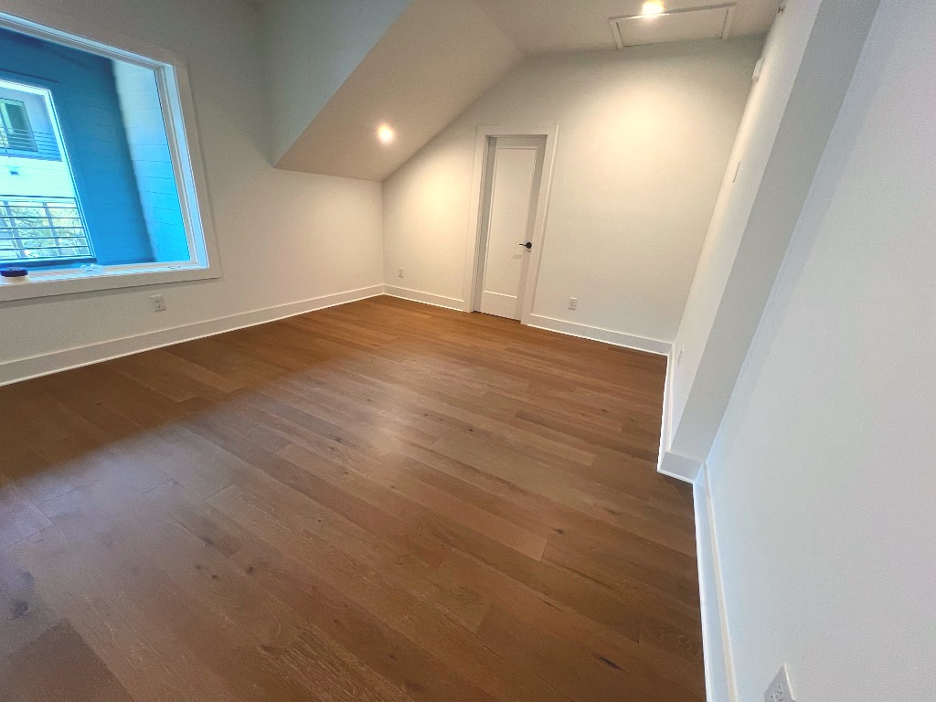 Bonus room with sloped architectural ceiling and wide plank hardwood flooring by CRG Flooring