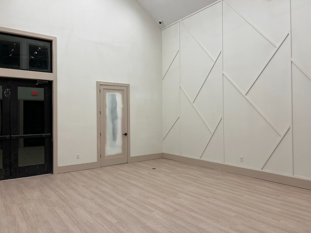 Commercial community clubhouse hall with high ceilings, architectural accent trim, and wide-plank luxury vinyl