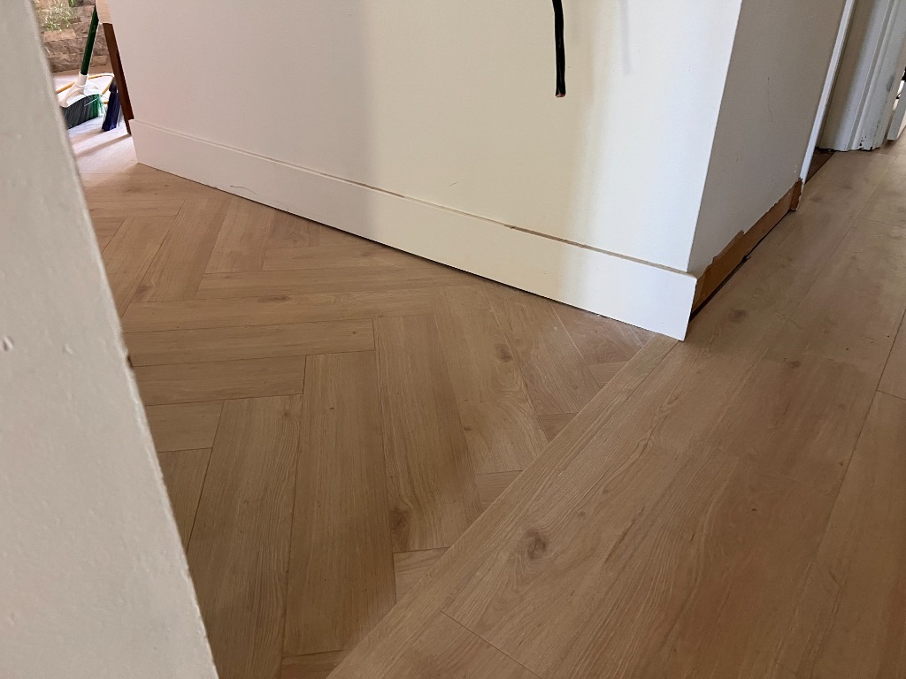 Custom herringbone pattern with flush border transition by CRG Flooring